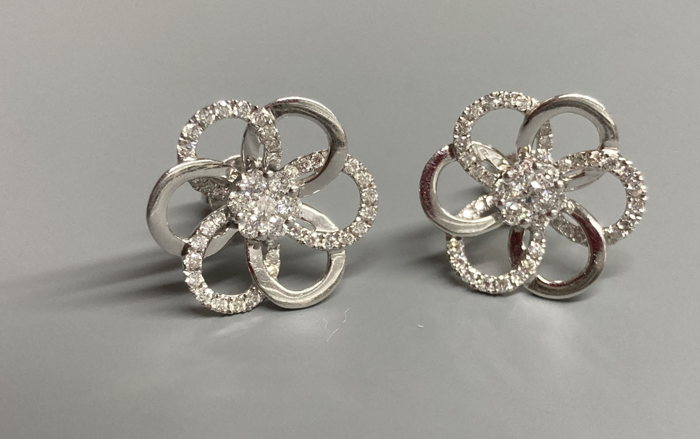 A modern pair of 18ct white gold and diamond cluster set openwork flower head ear studs, diameter 16mm, gross weight 4.4 grams.